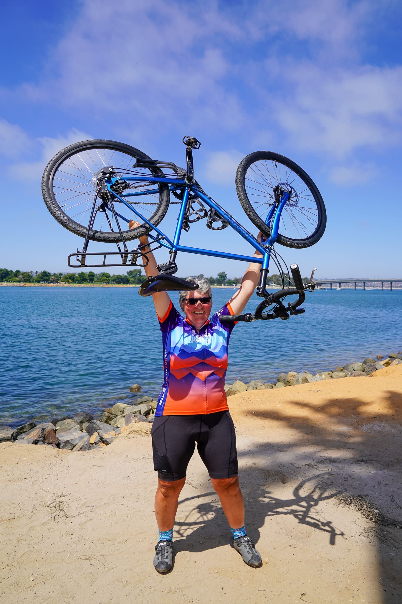 Rider lifting bike in celebration with Bike the US for MS